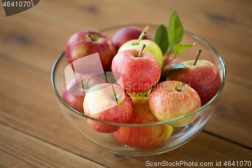 Image of ripe apples in glass bowl on wooden table