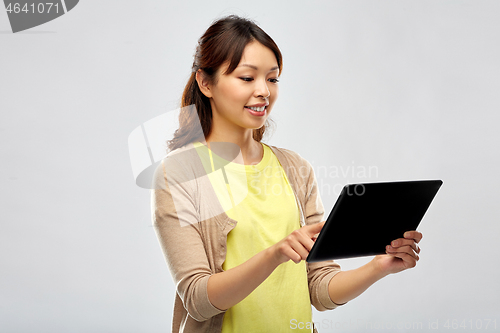 Image of happy asian woman using tablet computer