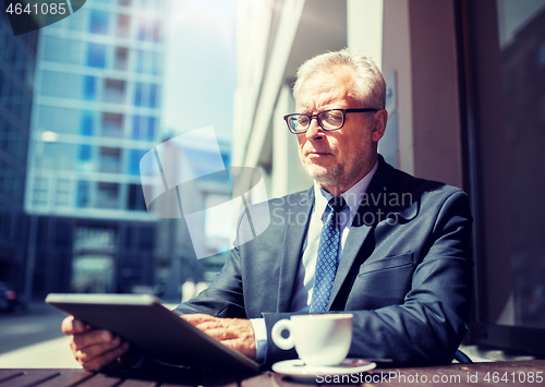 Image of senior businessman with tablet pc drinking coffee