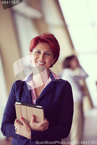 Image of business woman  at office with tablet  in front  as team leader