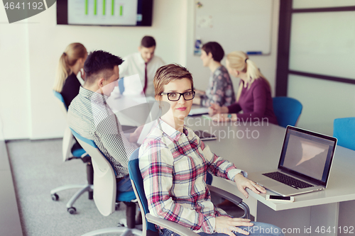 Image of young business woman at office working on laptop with team on me