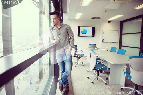 Image of young business man using smart phone at office