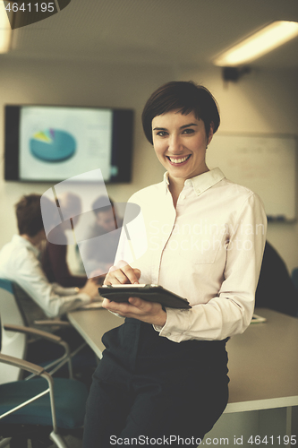 Image of hispanic businesswoman with tablet at meeting room