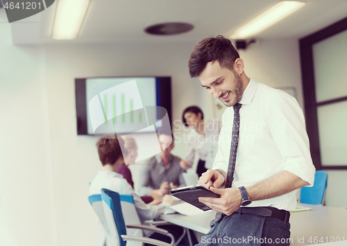 Image of young business man with tablet at office meeting room