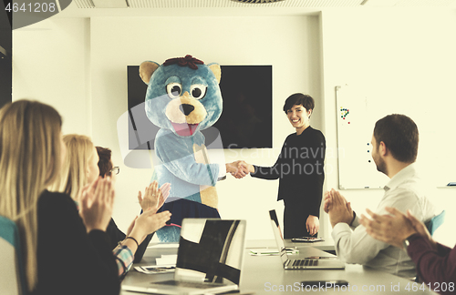 Image of boss dresed as bear having fun with business people in trendy of