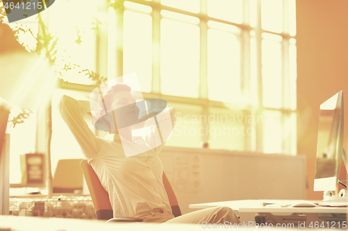 Image of young business woman relaxing at workplace