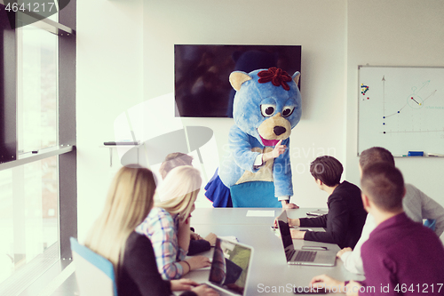 Image of boss dresed as bear having fun with business people in trendy of