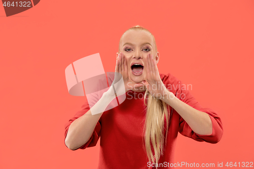 Image of Isolated on coral young casual woman shouting at studio