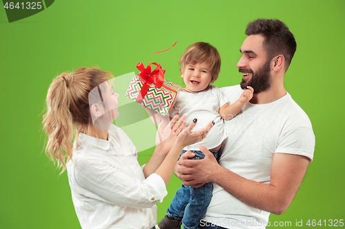 Image of happy family with kid together and smiling at camera isolated on green