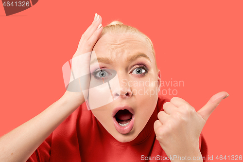 Image of Beautiful woman looking suprised isolated on coral