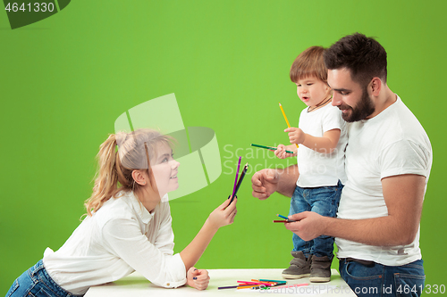 Image of happy family with kid together and smiling at camera isolated on green