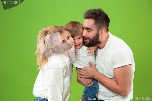 Image of happy family with kid together and smiling at camera isolated on green