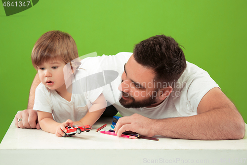 Image of happy family with kid together and smiling at camera isolated on green