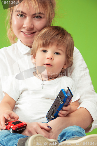 Image of happy family with kid together and smiling at camera isolated on green