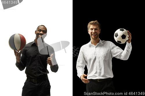 Image of Portrait of a smiling men holding soccer and basketball ball isolated on a white and black background