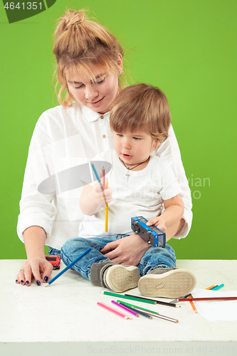 Image of happy family with kid together and smiling at camera isolated on green