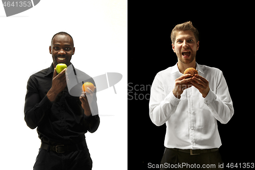 Image of Men eating a hamburger and fruits on a black and white background