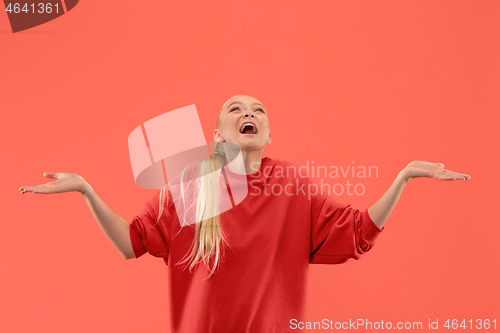 Image of The happy business woman standing and smiling against coral background.