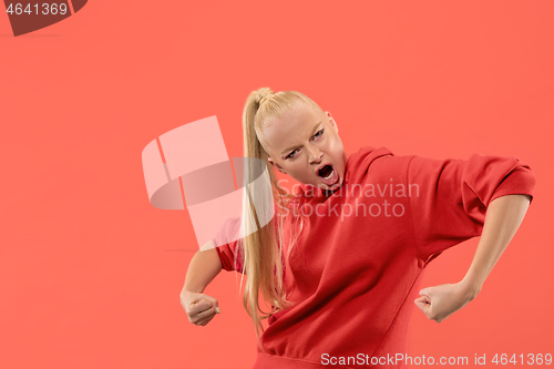 Image of The young emotional angry woman screaming on coral studio background