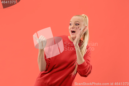 Image of Isolated on coral young casual woman shouting at studio