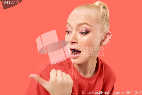 Image of Beautiful woman looking suprised isolated on coral