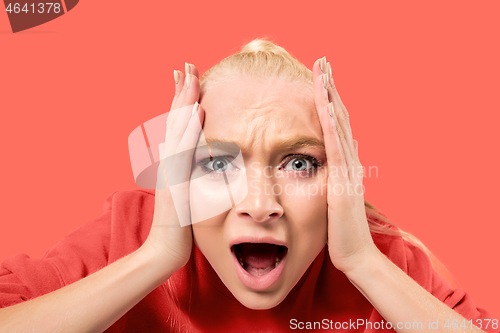 Image of The young emotional angry woman screaming on coral studio background