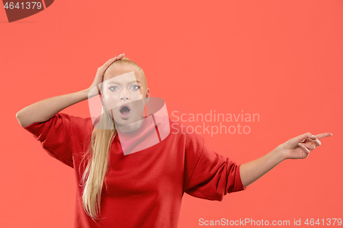 Image of Beautiful woman looking suprised isolated on coral