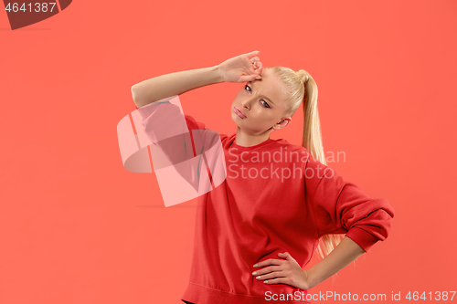 Image of Beautiful woman looking suprised and bewildered isolated on coral