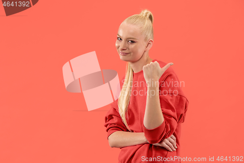 Image of Beautiful woman looking suprised isolated on coral