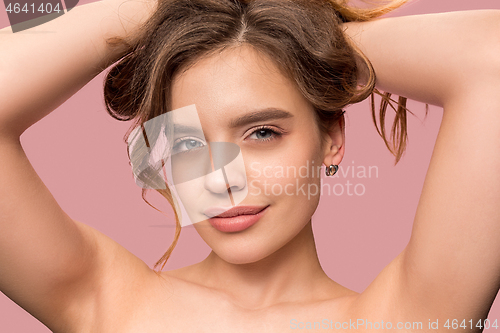 Image of Nice young smiling woman with long wavy silky hair, natural make up looking at camera
