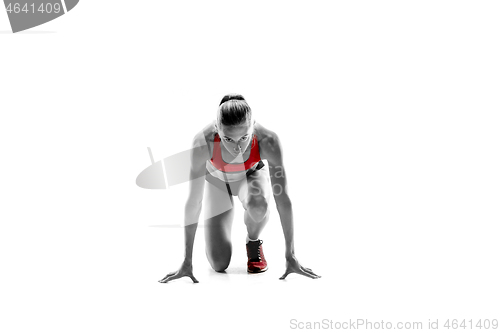 Image of Portrait of young sporty woman at starting block of race isolated over white background