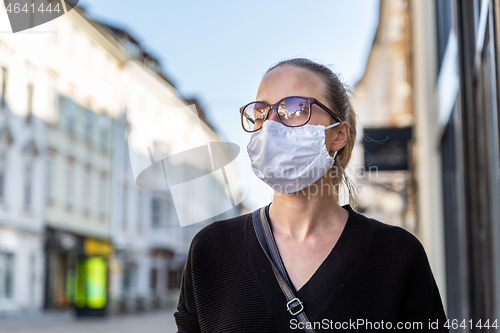 Image of COVID-19 Pandemic Coronavirus. Young girl in city street wearing face mask protective for spreading of Coronavirus Disease 2019. Close up of young woman with medical mask on face against SARS-CoV-2