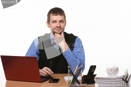 Image of A confident man sits at the computer on a white background