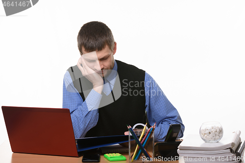 Image of puzzled manager looks at the papers at the table on a white background