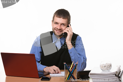 Image of Entrepreneur talks on the phone at the desk on a white background