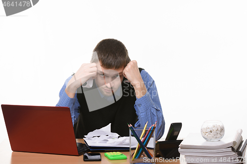 Image of Office worker unsuccessfully comes up with new ideas at the desk