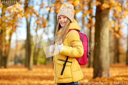 Image of happy student girl with schoolbag at autumn park