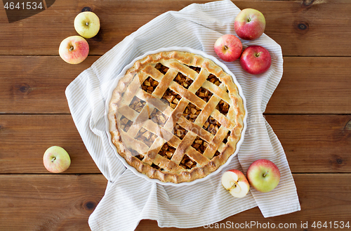 Image of apple pie in baking mold on wooden table