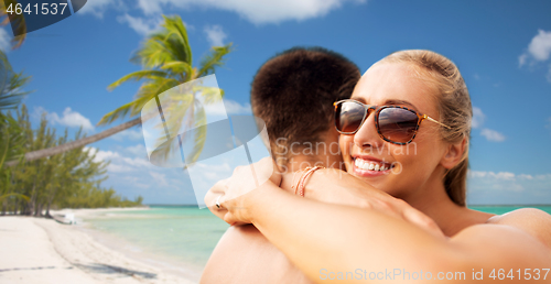 Image of happy couple hugging on summer beach