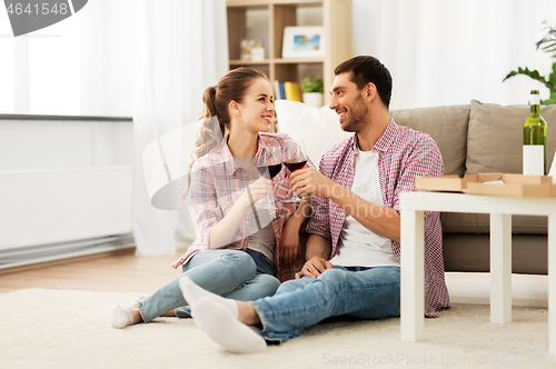 Image of happy couple drinking red wine at home