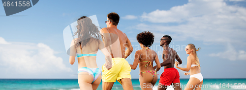 Image of happy friends running on summer beach