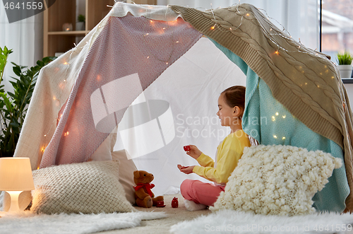 Image of girl playing tea party with teddy in kids tent