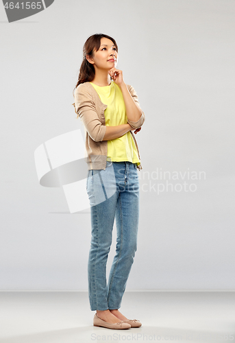 Image of asian woman thinking over grey background
