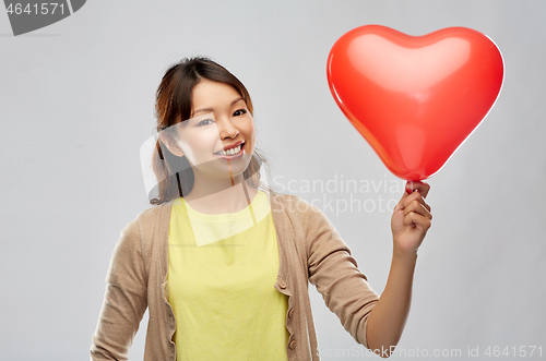 Image of happy asian woman with red heart shaped balloon