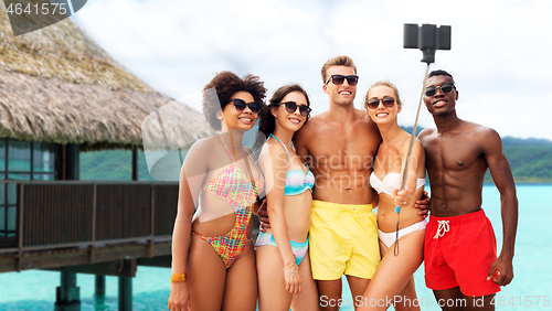 Image of happy friends taking selfie on summer beach