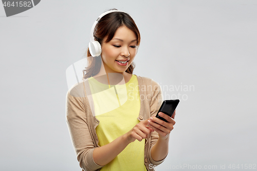 Image of asian woman in headphones listening to music