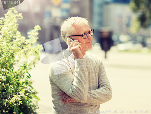 Image of happy senior man calling on smartphone in city