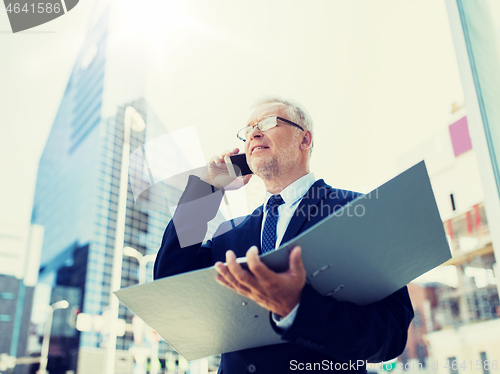 Image of senior businessman calling on smartphone in city