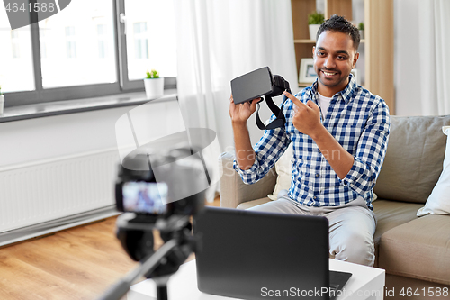 Image of male blogger with vr glasses videoblogging at home