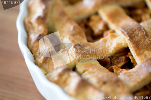 Image of close up of apple pie in mold on wooden table